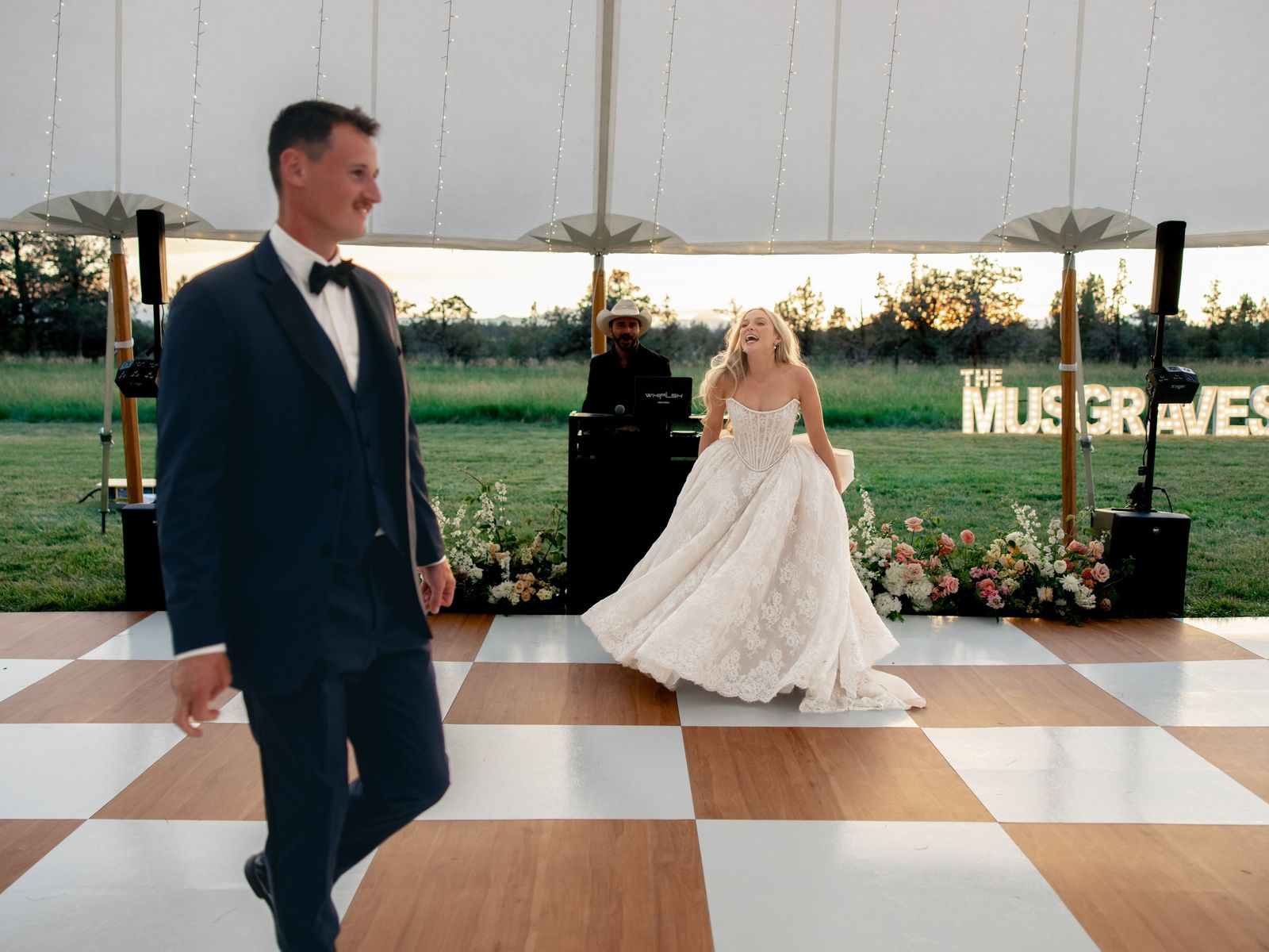 Bride dancing on a checkered floor with WHIPLSH at the booth, Central Oregon sunset