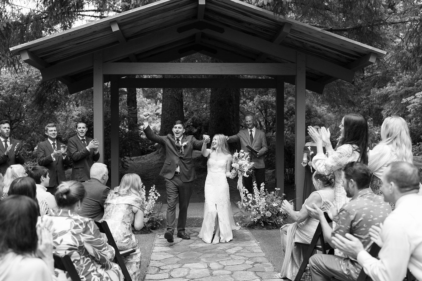 Just-married recessional under a forest pavilion