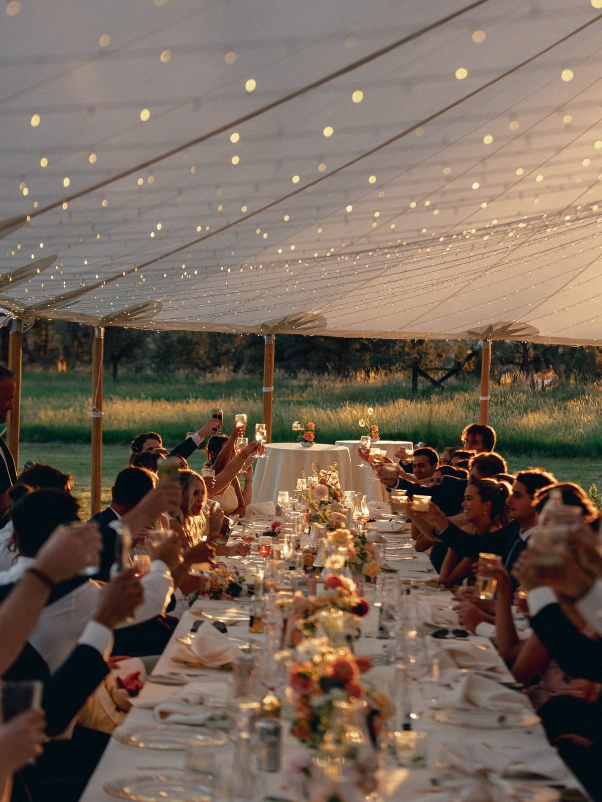 Dinner toast under a string-lit tent