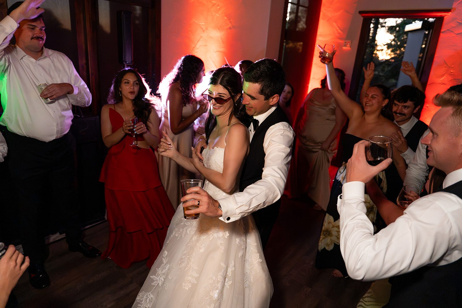 Bride and groom dancing under red uplights