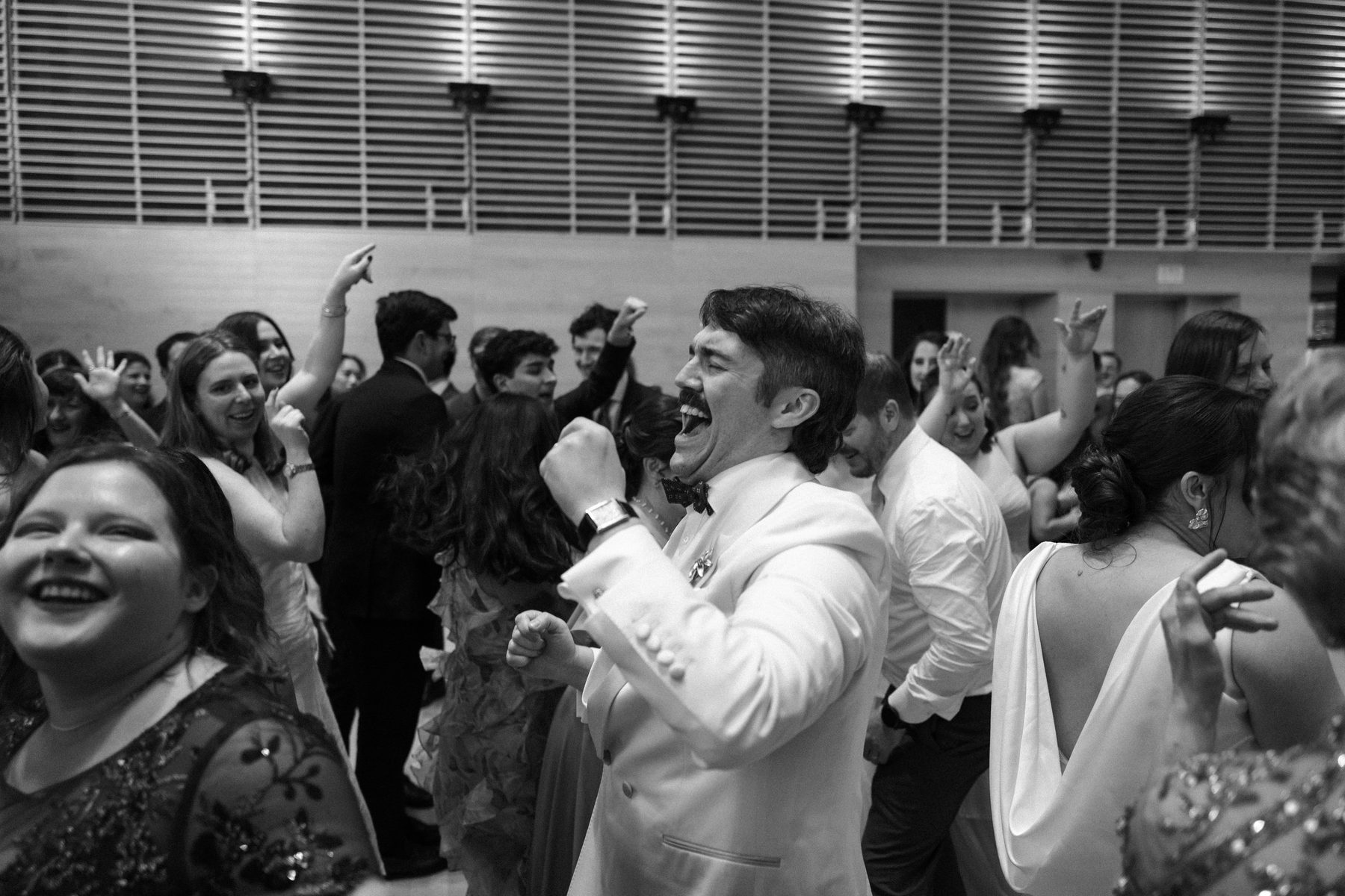 Groom in the middle of a packed floor, singing every word