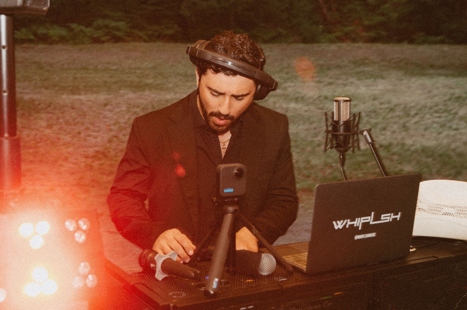 WHIPLSH mixing live with headphones and branded laptop