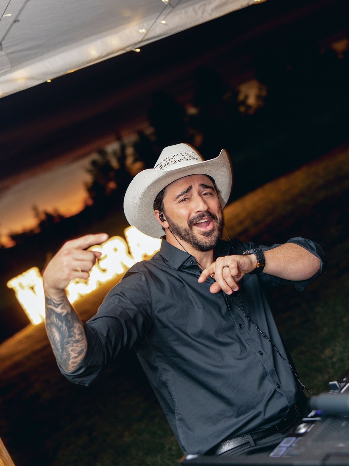 WHIPLSH mixing at sunset in a cowboy hat