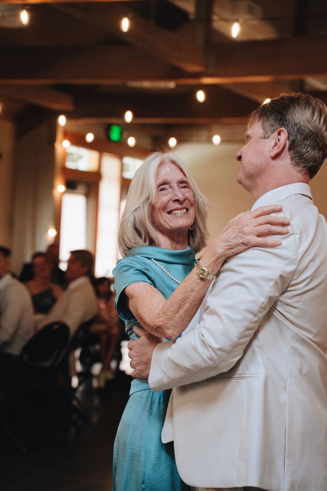 Parents slow dancing under cafe lights