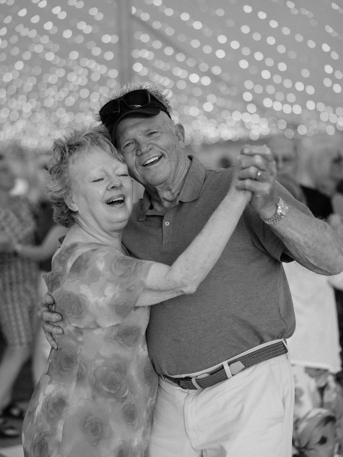 An older couple dancing, packed floor behind them