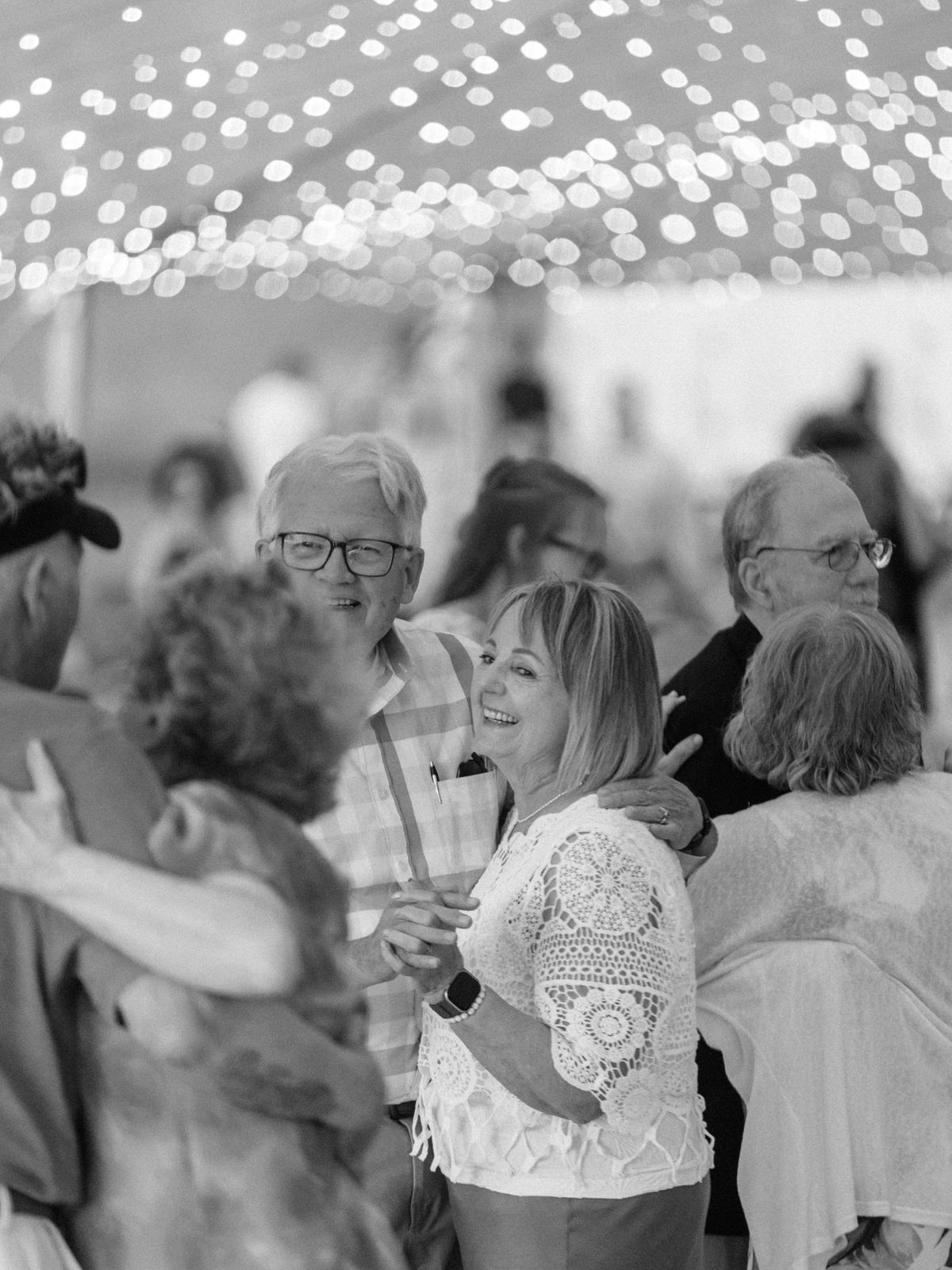 Guests dancing under tent lights