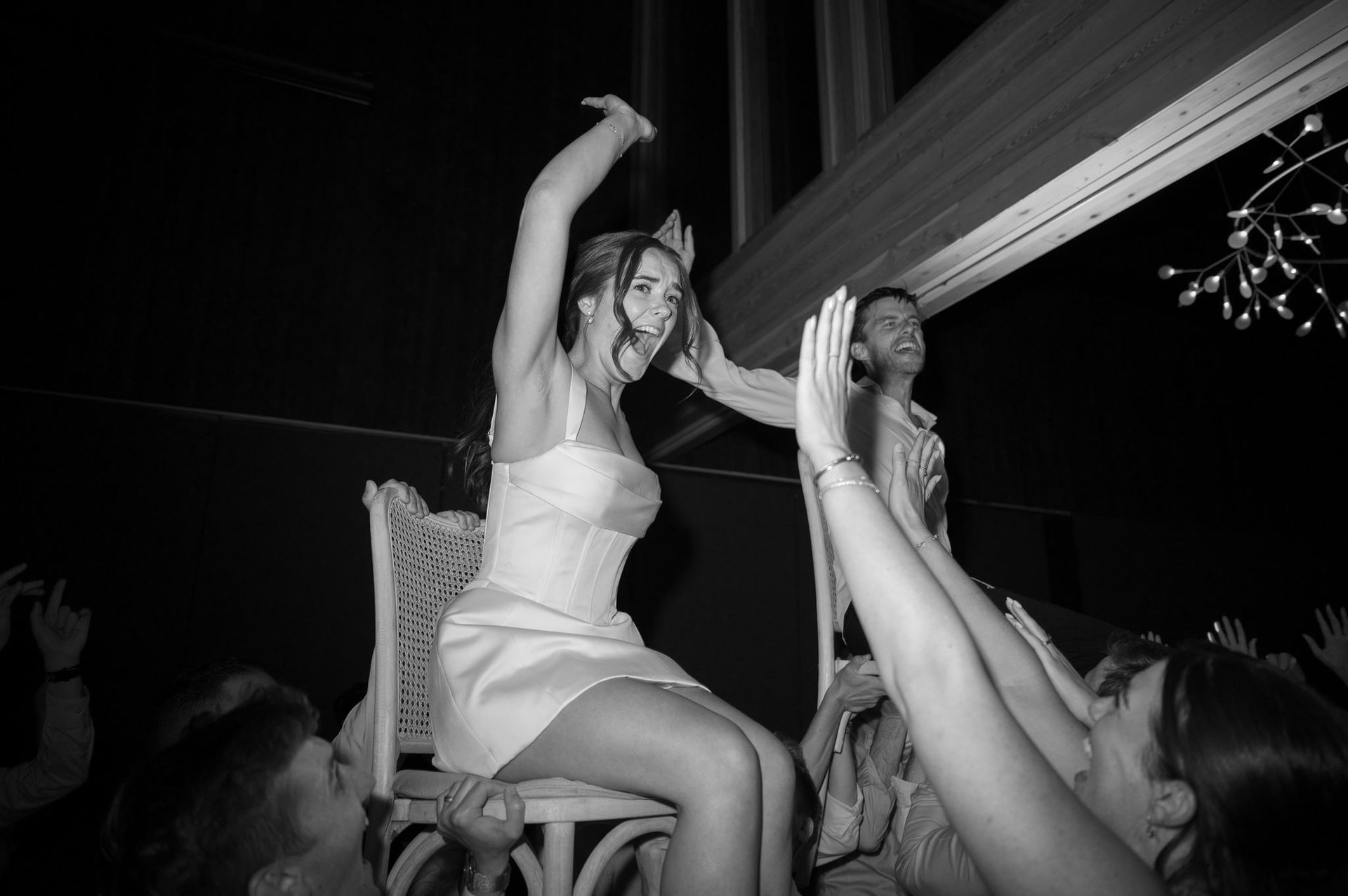 Bride and groom lifted on chairs, the room roaring