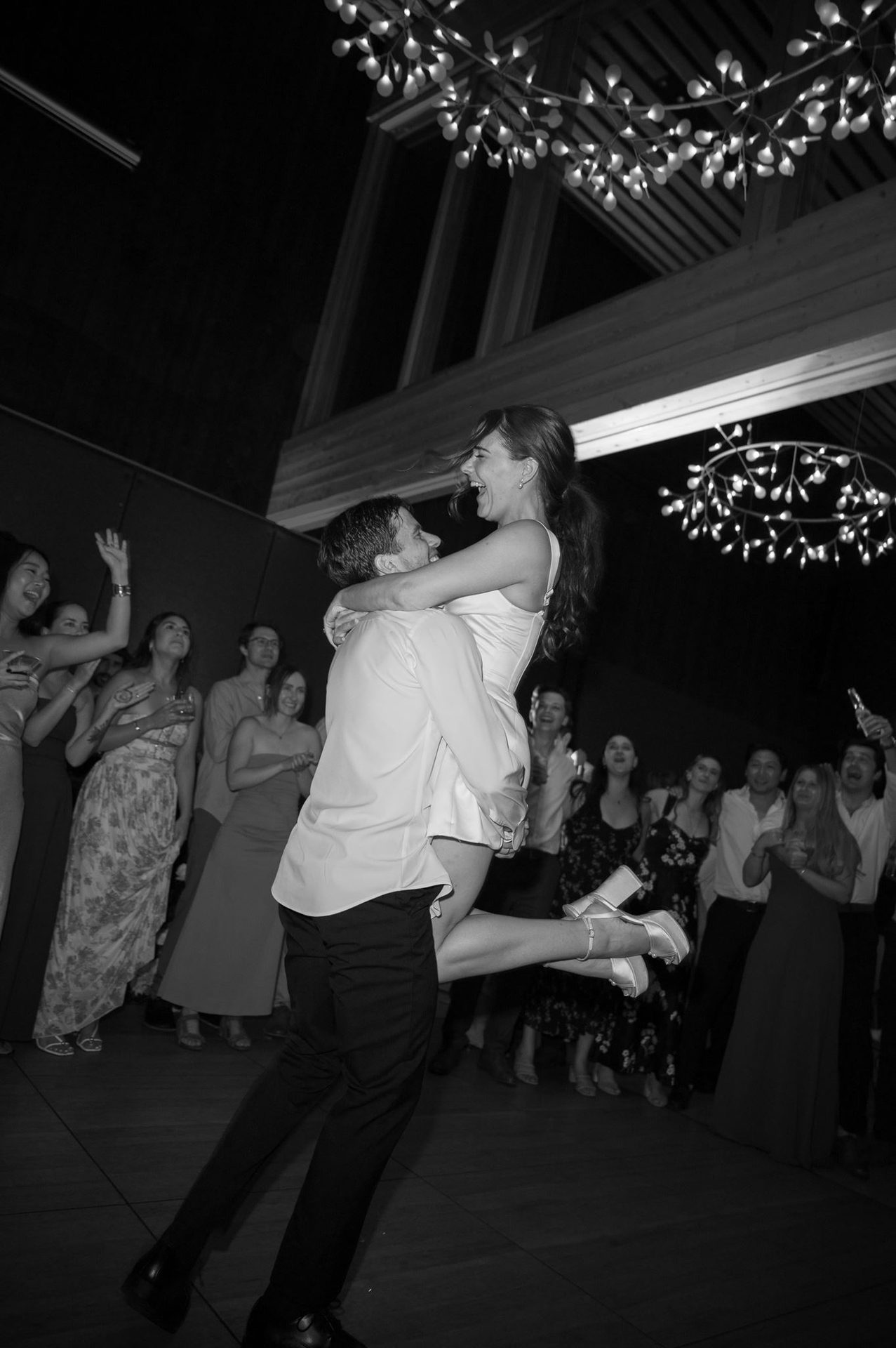 Groom lifting the bride while the floor packs in