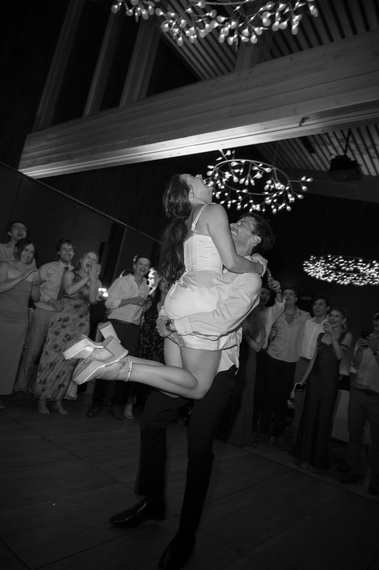 Bride in the air, guests circled around