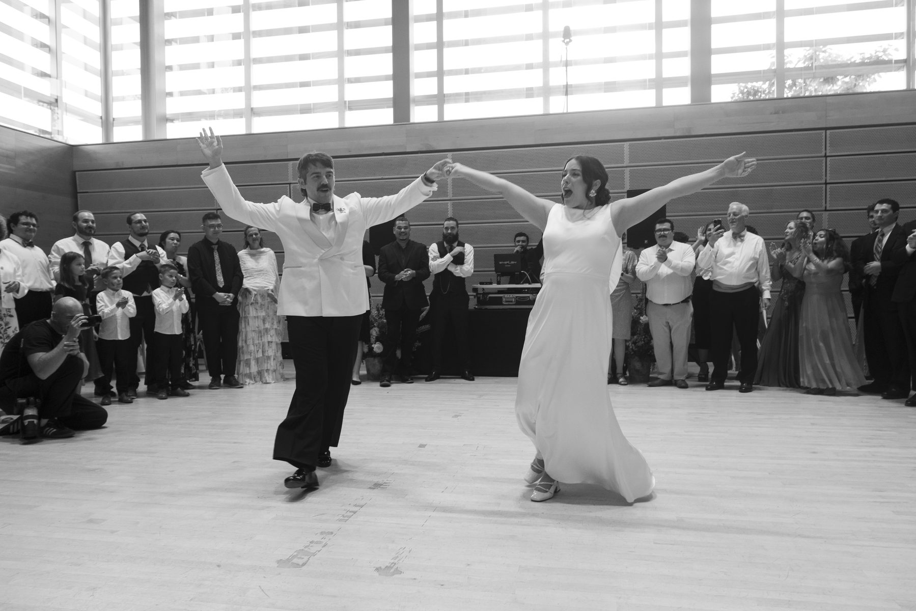 First dance, arms wide, the room watching
