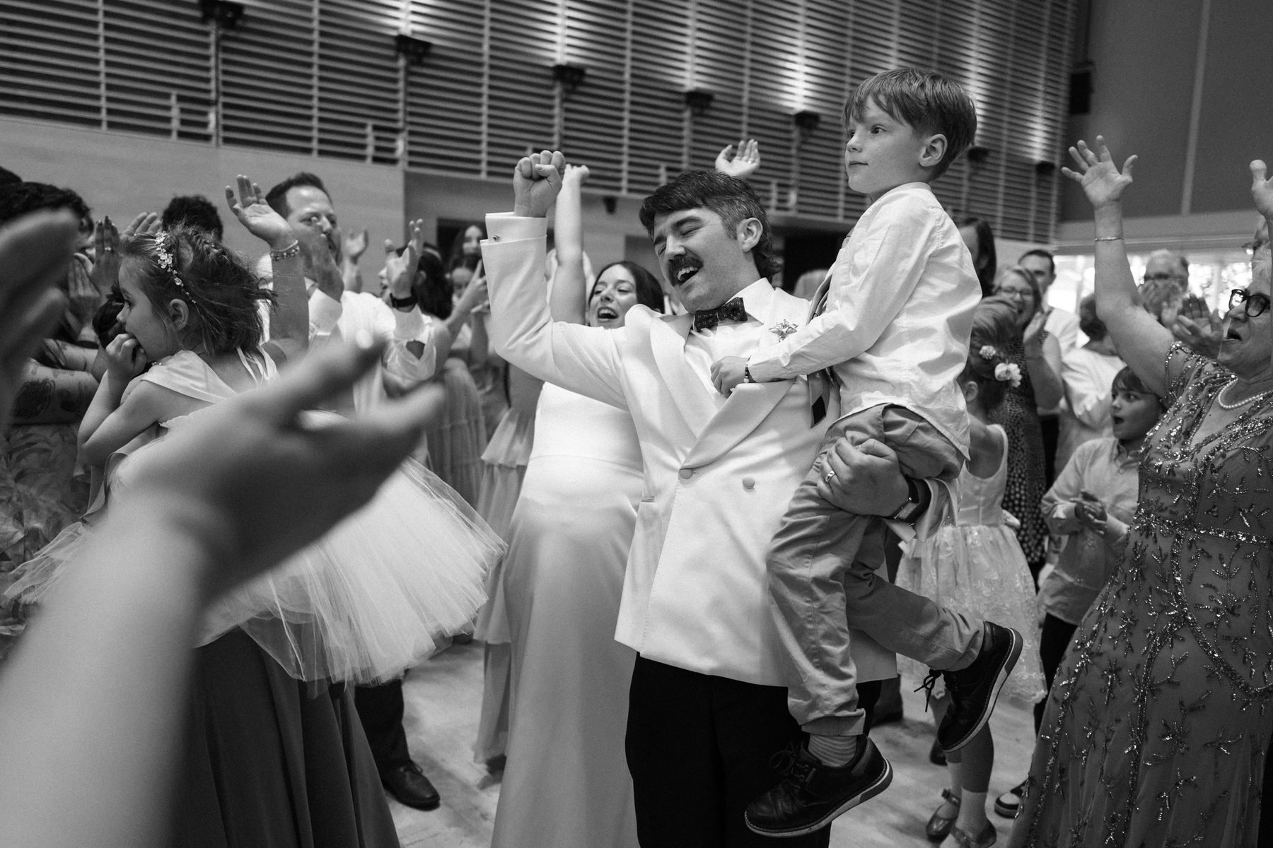 Groom with his son on his hip as the floor goes off